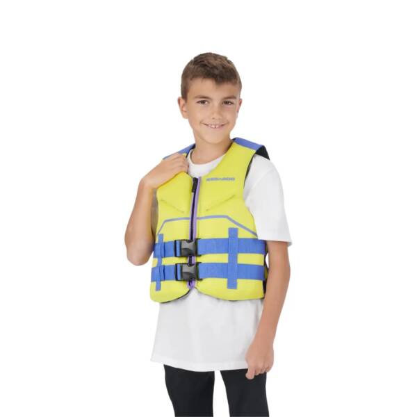 Bambino con giubbotto Sea-Doo Junior PFD Freedom indossato, in ecoprene giallo con zip YKK e aperture ampie per le braccia, in primo piano. Colore yellow alta visibilità