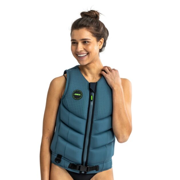 Donna che indossa il giubbotto salvagente Jobe Fragment colore Denim blue, in neoprene stretch, con cerniera YKK, anello D e pannelli in schiuma separata, ideale per sport acquatici