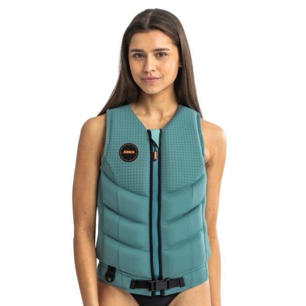 Donna che indossa il giubbotto salvagente Jobe Fragment colore Vintage teal, in neoprene stretch, con cerniera YKK, anello D e pannelli in schiuma separata, pronta per sport acquatici